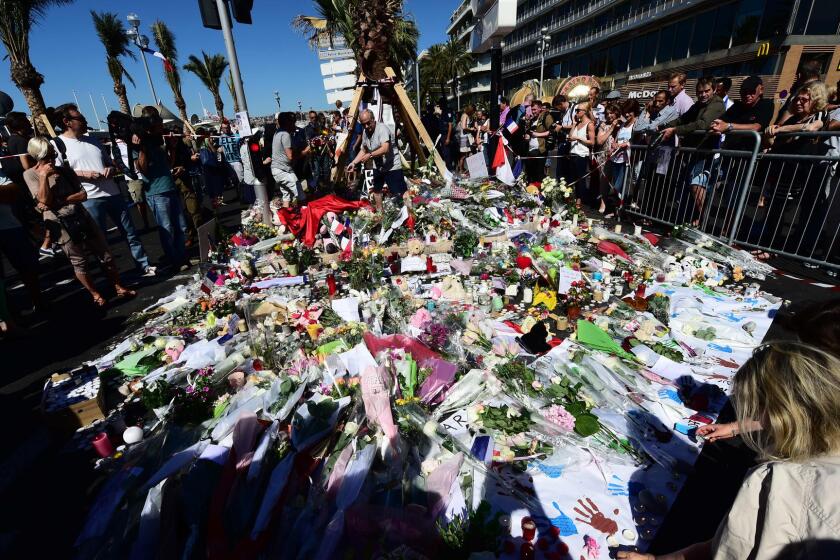 Mourners place flowers, candles and messages at a makeshift memorial on Nice's seaside promenade on July 16, 2016.