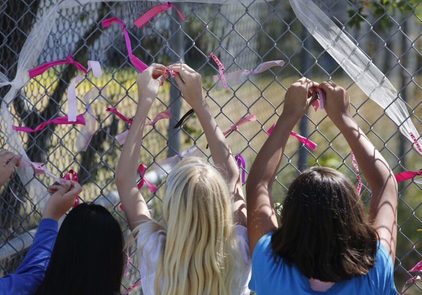 Students at Valley Spring's Jenny Lind Elementary School tie ribbons Monday honoring their classmate, 8-year-old Leila Fowler, who was fatally stabbed in her family's home.