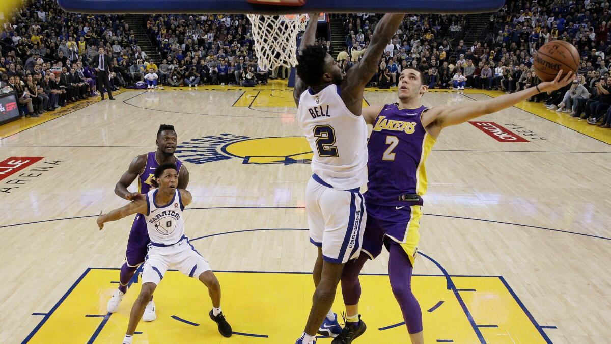 Lakers guard Lonzo Ball drives to the basket as Golden State Warriors forward Jordan Bell defends during the second half Friday.