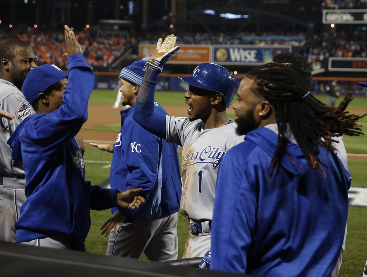 Kansas City Royals' Jarrod Dyson (1), right, celebrates with with his teammates after scoring on an RBI single by Christian Colon during the 12th inning of Game 5 of the Major League Baseball World Series against the New York Mets Monday, Nov. 2, 2015, in New York. (AP Photo/Matt Slocum)