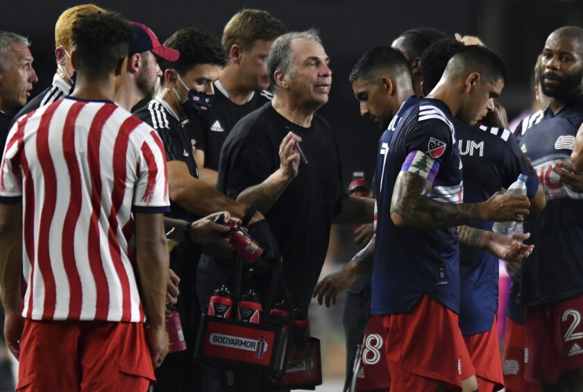 Revolution coach Bruce Arena speaks to his team during a hydration break 