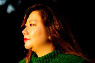 A woman in sunlit profile in a green sleeveless sweater.