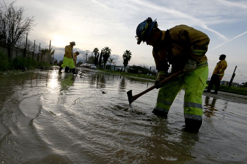 ALLENSWORTH, CALIF. - M,AR. 20, 2023. A Cal Fire crew trenches a flooded raod in an attempt to lower the water in Allensworth on Monday, Mar. 20, 2023. Portions of the town have been flooded during recent rains and residents are bracing for a forecasted storm that may further innundate the community. (Luis Sinco / Los Angeles Times)