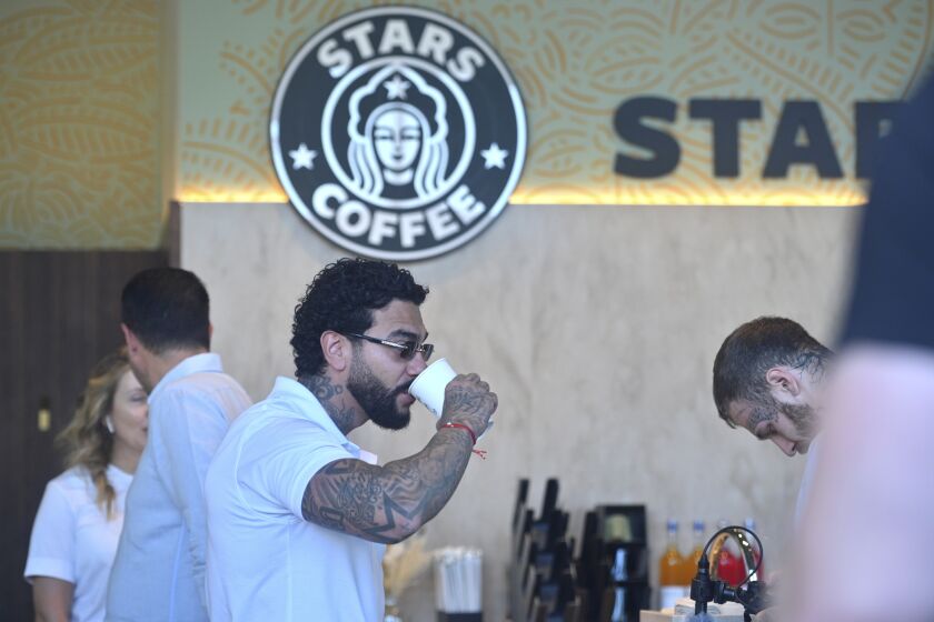 Russian singer and entrepreneur Timur Yunusov, better known as Timati, drinks coffee at a newly opened Stars Coffee coffee shop in the former location of the Starbucks coffee shop in Moscow, Russia, Thursday, Aug. 18, 2022. A new chain of coffee shops opens Thursday in Moscow, after Russian singer and entrepreneur Timur Yunusov, better known as Timati, together with Russian restaurateur Anton Pinskiy bought the Starbucks stores following company's withdrawal from Russia. (AP Photo/Dmitry Serebryakov)