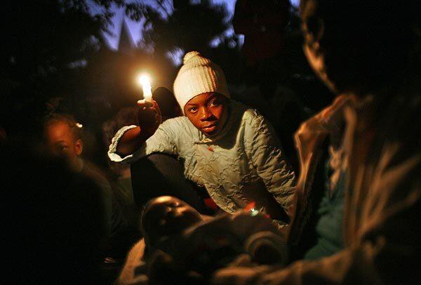Thousands of people in the battered Haitian capital are still too afraid to sleep in their homes. A family gathers around a candle waiting for the sun to rise on the third night after the quake. They were singing hymns throughout the night. More photos from Haiti