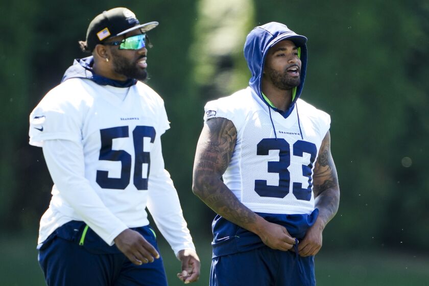 Seattle Seahawks linebacker Jordyn Brooks (56) and safety Jamal Adams (33) talk during NFL football practice, Tuesday, June 6, 2023, at the team's facilities in Renton, Wash. (AP Photo/Lindsey Wasson)