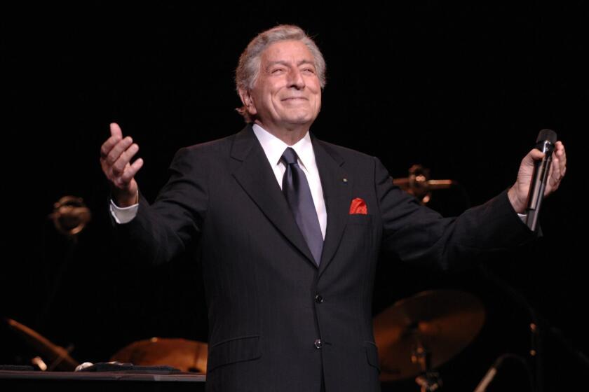 Tony Bennett outstretching his arms onstage