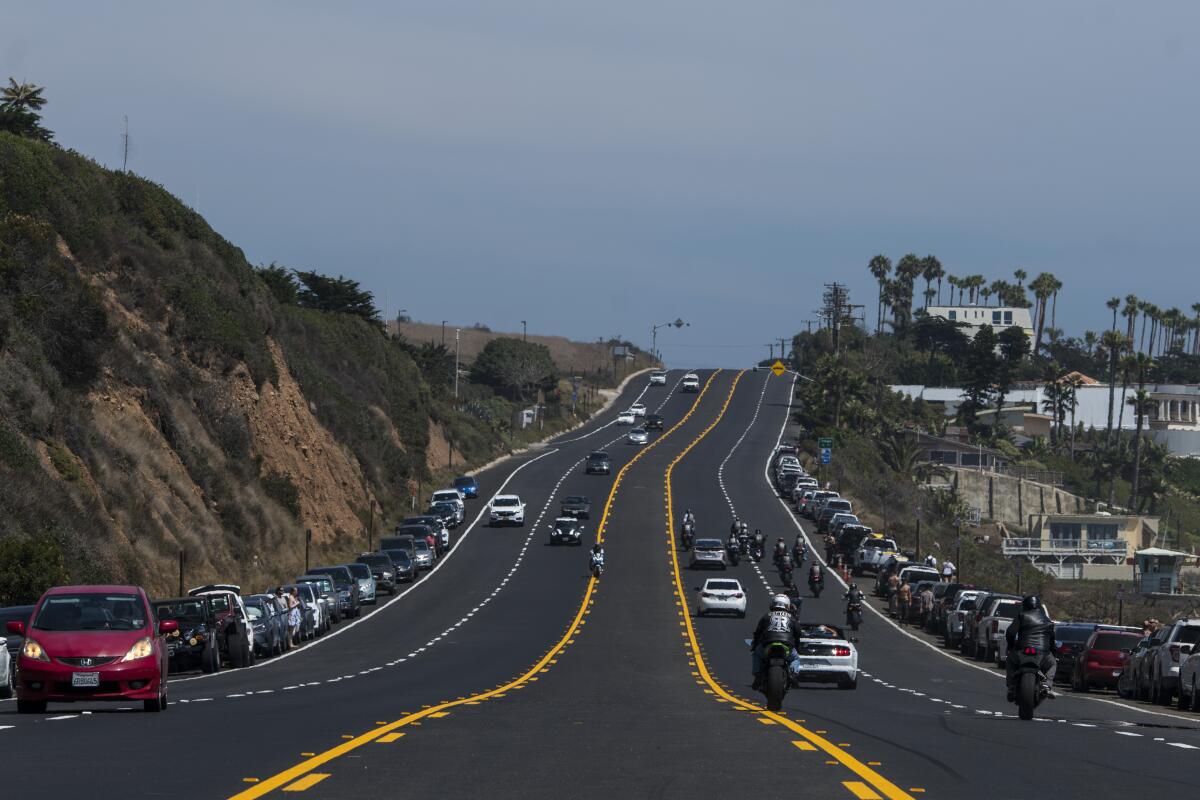 A long stretch of highway with cars driving along it in both directions