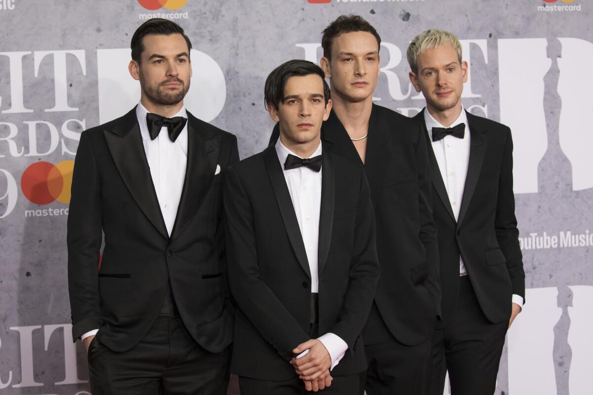 Matthew Healy, from left, Ross MacDonald, George Daniel and Adam Hann of the 1975 pose in tuxedos