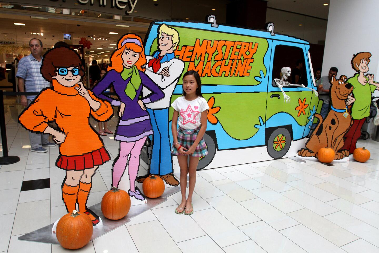 Mercy Prather, 11 of Montrose, poses with the Scooby-Doo gang, Velma, Daphne, Fred, Scooby and Shaggy, which are made from legos, at the Glendale Galleria in Glendale on Saturday, October 31, 2015. The characters and the Mystery Machine were created with 70, 875 lego pieces, took 86 hours to design and 525 hours to build and glue together. This was the last stop of the 8-city LEGO Scooby-Doo Mystery Tour.