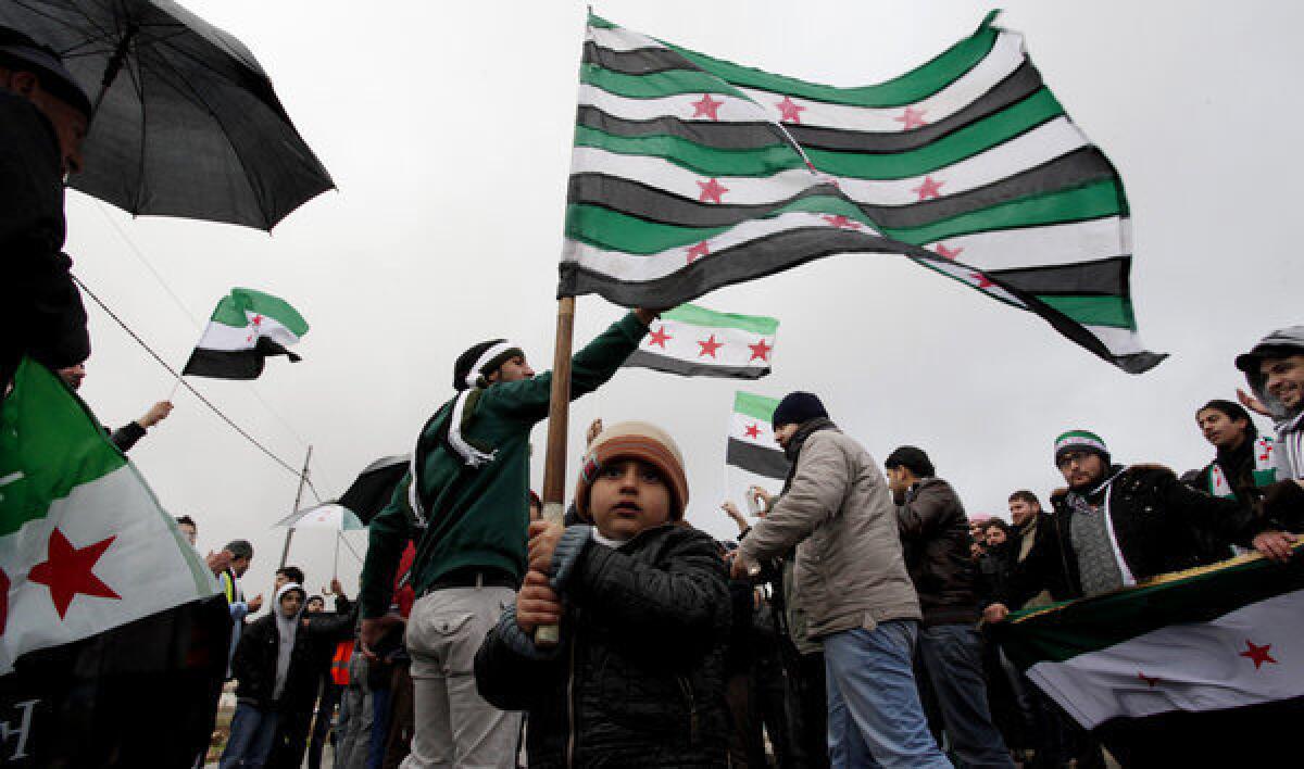 Syrians, many of them refugees from the 21-month-old uprising in their homeland, chant denunciations of Syrian President Bashar Assad outside the Syrian Embassy in Amman, Jordan.