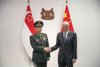 El ministro de Defensa de China, el general Li Shangfu (izquierda), estrecha la mano a su homólogo de Singapur, Ng Eng Hen, en Singapur, el 1 de junio de 2023. (AP Foto/Vincent Thian)