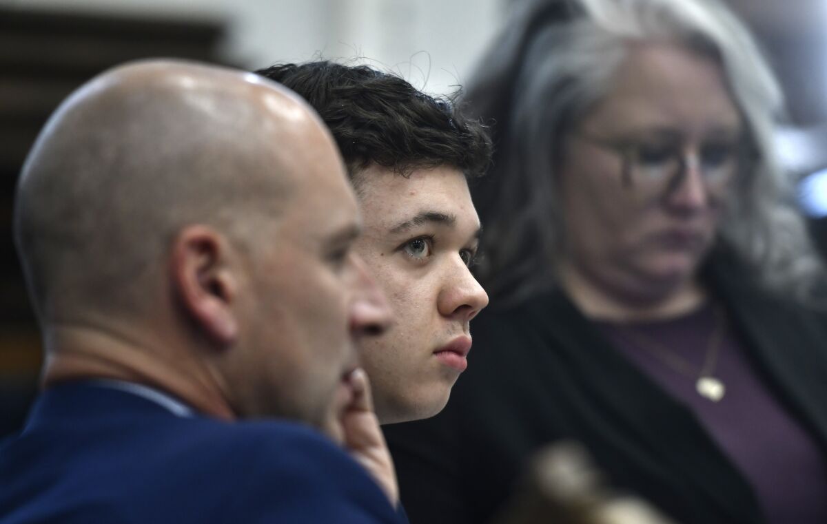Kyle Rittenhouse, center, looks up and away from a video monitor as footage of him shooting on the night of Aug. 25, 2020, is shown during the trial at the Kenosha County Courthouse in Kenosha, Wis., on Wednesday, Nov. 3 2021. (Sean Krajacic/The Kenosha News via AP, Pool)