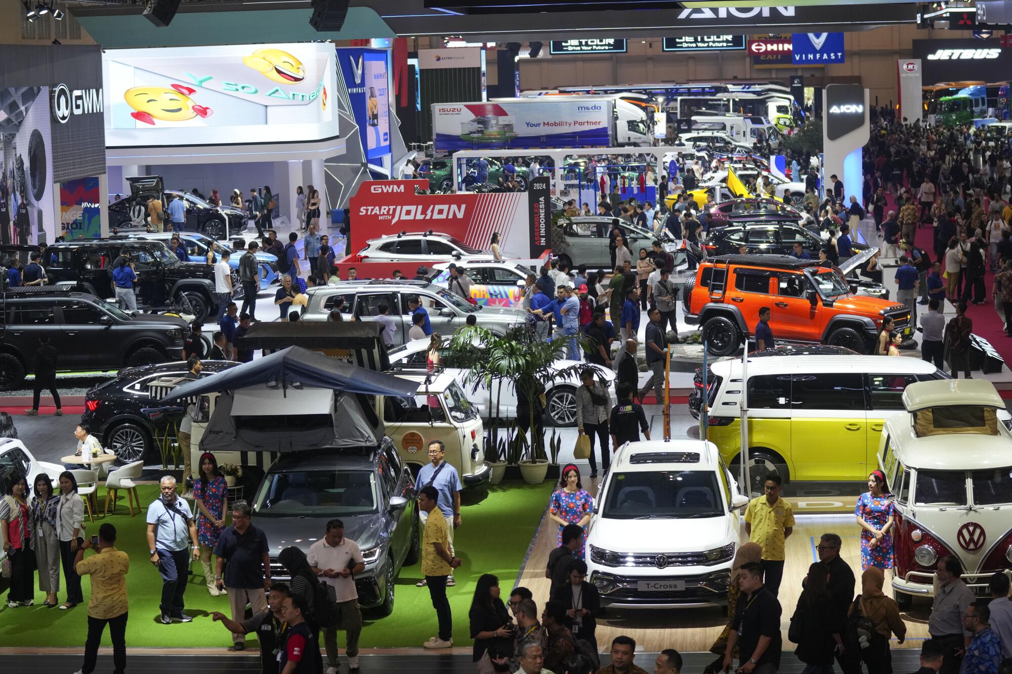 Visitors look at vehicles during an auto show