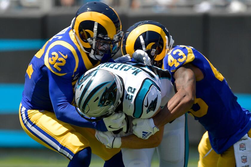 Eric Weddle #32 and John Johnson #43 of the Los Angeles Rams tackle Christian McCaffrey #22 of the Carolina Panthers during the second quarter of their game at Bank of America Stadium on September 08, 2019 in Charlotte, North Carolina. (Photo by Grant Halverson/Getty Images)
