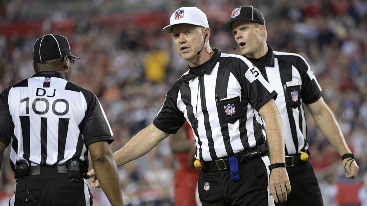 Referee Carl Cheffers, center, talks with down judge Tom Symonette (100) and umpire Clay Martin, right, during the second half of Thurday's game between the Tampa Bay Buccaneers and the New England Patriots.