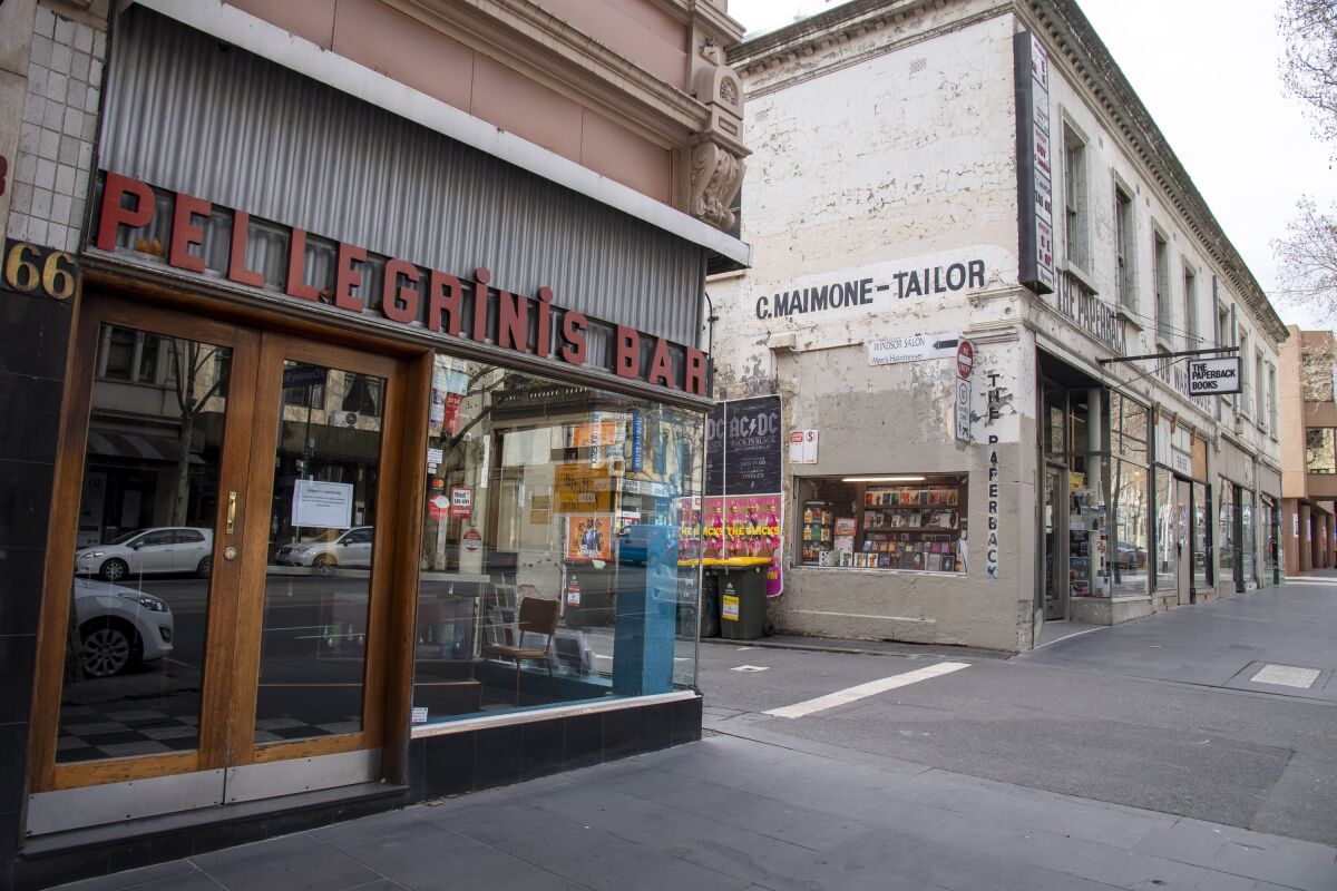 Pellegrinis Cafe and The Paperback book store are closed during lockdown due to the continuing spread of the coronavirus in Melbourne, Thursday, Aug. 6, 2020. Victoria state, Australia's coronavirus hot spot, announced on Monday that businesses will be closed and scaled down in a bid to curb the spread of the virus. (AP Photo/Andy Brownbill)