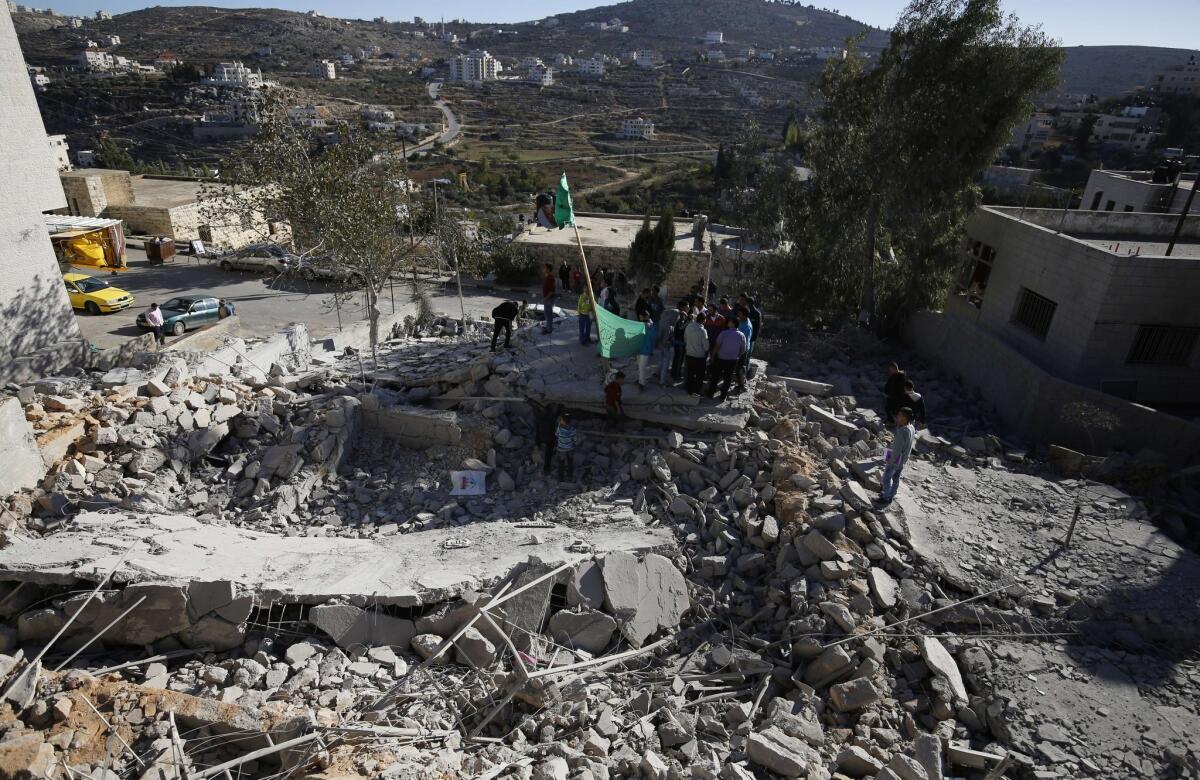 Palestinians look at rubble of the house of a Palestinian man who the Israeli military said killed an Israeli traveling to the West Bank in June. The home in Silwad was demolished Nov. 14 by the Israeli army.