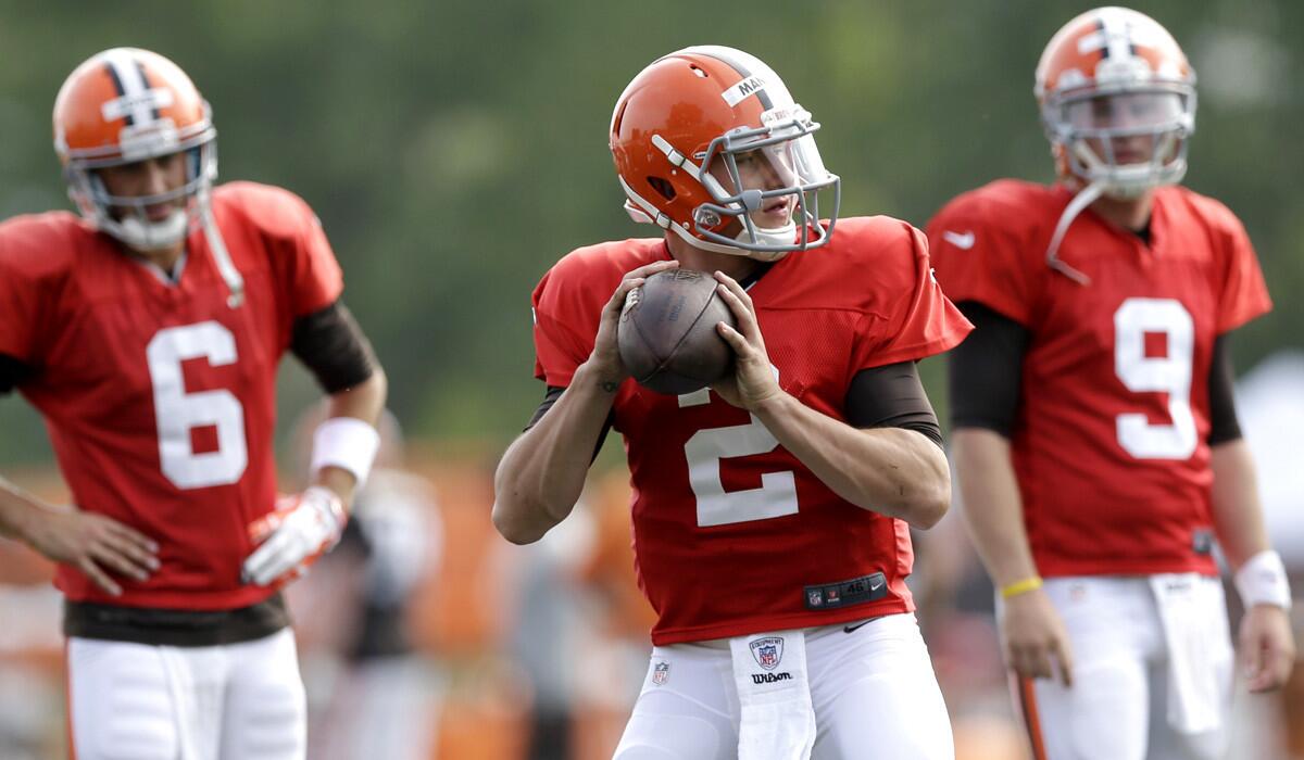Browns rookie Johnny Manziel gets ready to pass during a drill with fellow quarterbacks Brian Hoyer, left, and Connor Shaw on Tuesday.