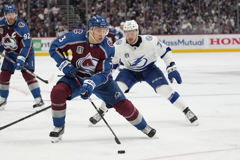 Avalanche defenseman Jack Johnson controls the puck ahead of Lightning center Ross Colton.