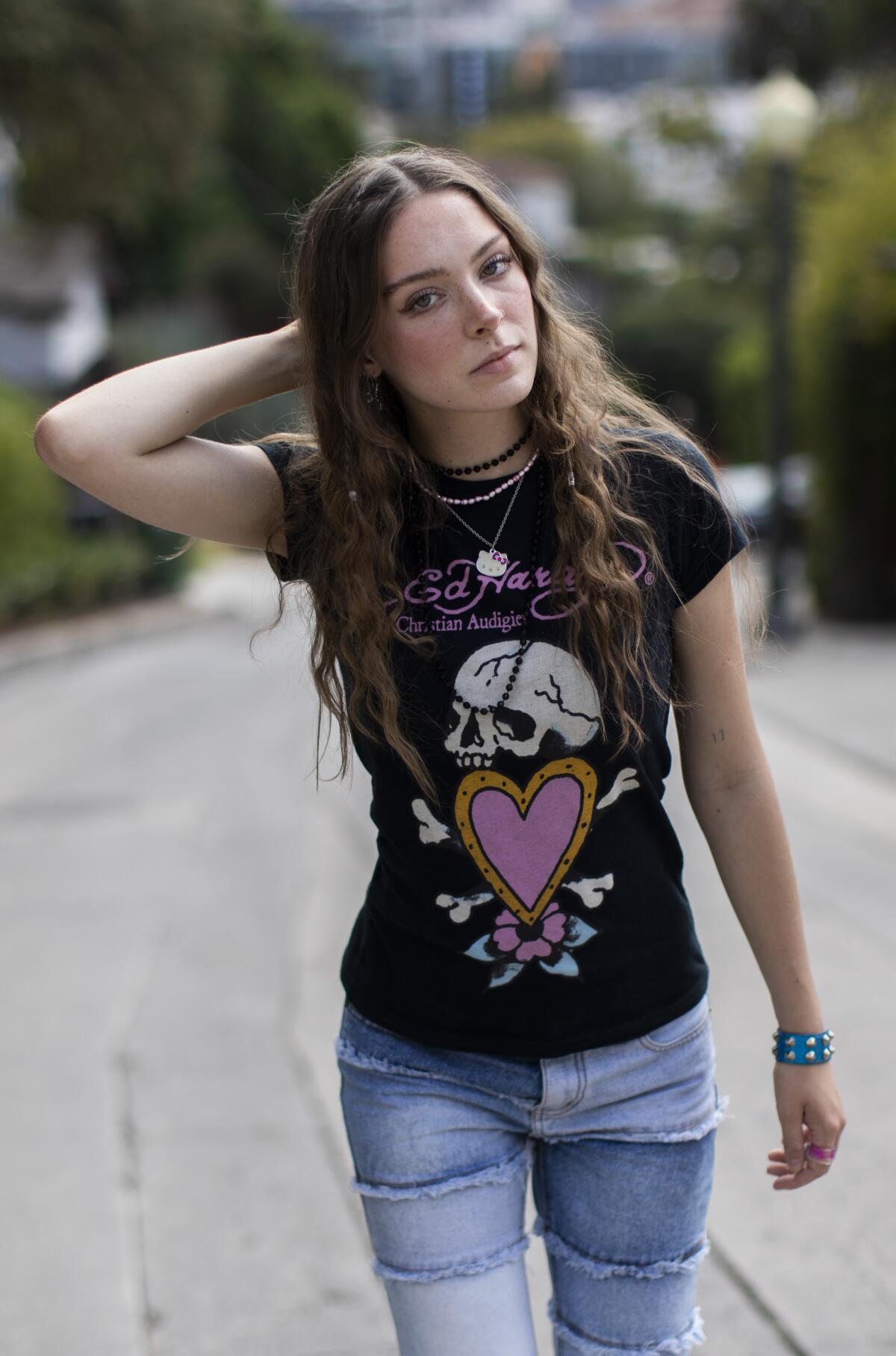 A young woman in T-shirt and jeans, in the middle of an empty street