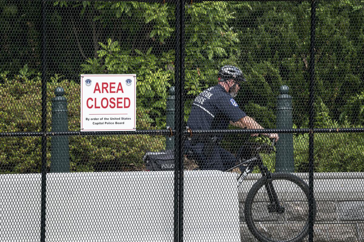 A U.S. Capitol Police officer patrols the barricaded perimeter of the Capitol grounds in Washington, Monday, June 14, 2021. (AP Photo/J. Scott Applewhite)