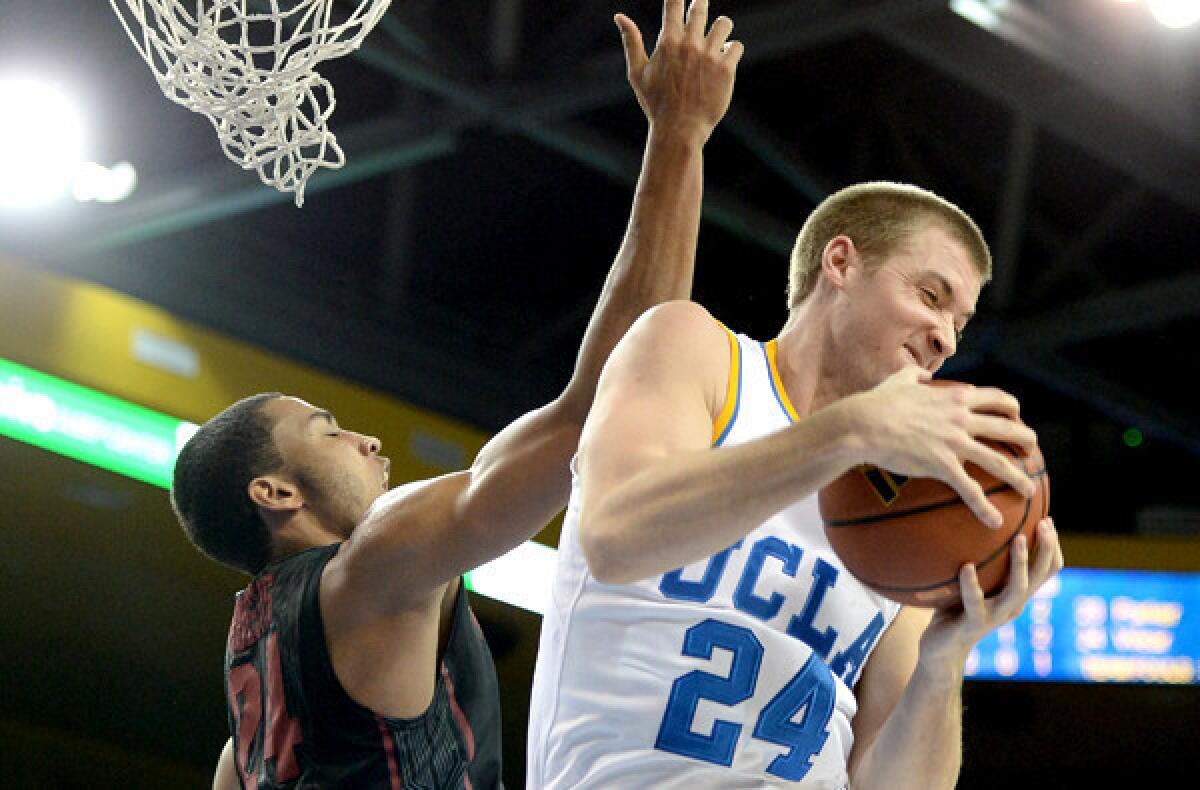 Bruins forward Travis Wear (24) pulls down a rebound against Stanford forward Josh Huestis during a game earlier this season at Pauley Pavilion.