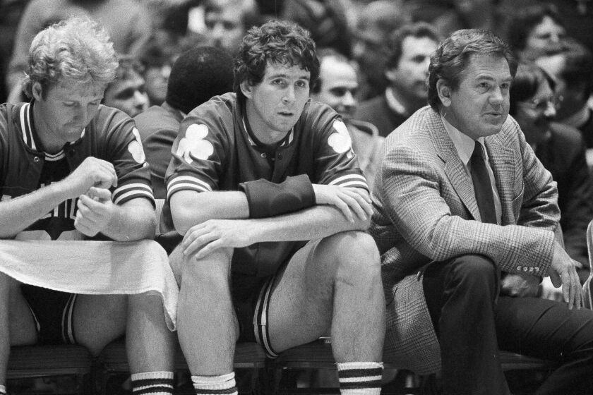 FILE - In this Dec. 21, 1982, file photo, Boston Celtics coach Bill Fitch and players Rick Robey, center, and Larry Bird watch from the bench as their team loses to the Philadelphia 76ers 122-105 in an NBA basketball game Philadelphia. Fitch is among 13 finalists for enshrinement later this year into the Basketball Hall of Fame. (AP Photo/Peter Morgan, File)