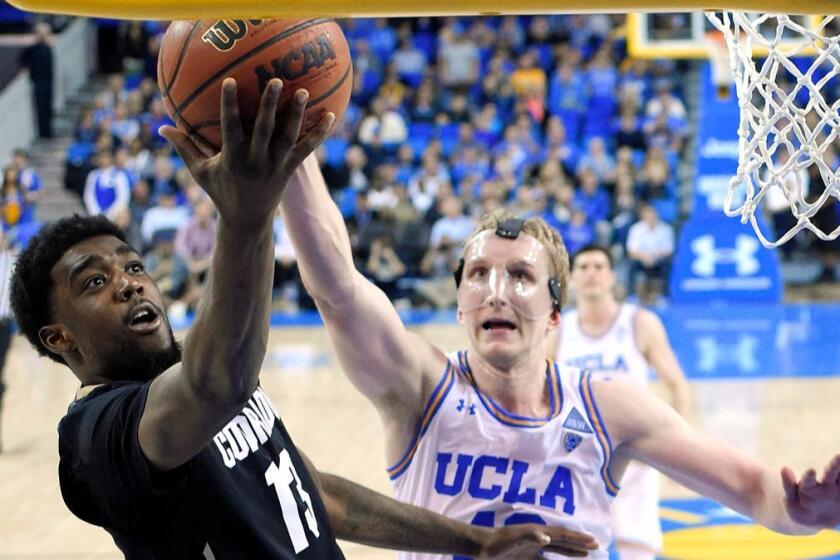 Colorado guard Namon Wright, left, shoots as UCLA center Thomas Welsh defends during the second half of an NCAA college basketball game Saturday, Jan. 13, 2018, in Los Angeles. Colorado won 68-59. (AP Photo/Mark J. Terrill)