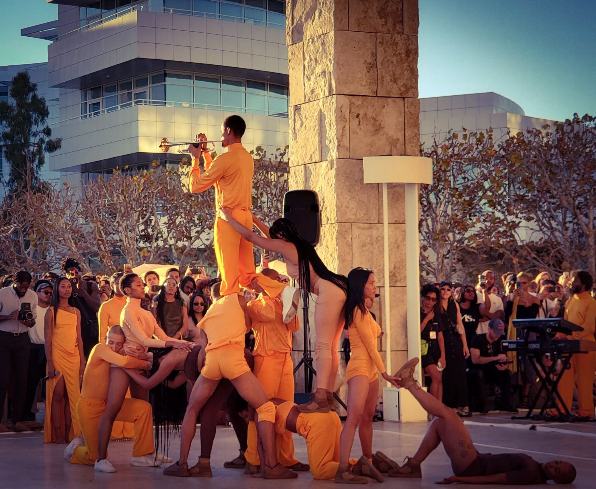R&B singer Solange, wearing sunglasses toward the left, watches a dance performance at the Getty Center. 