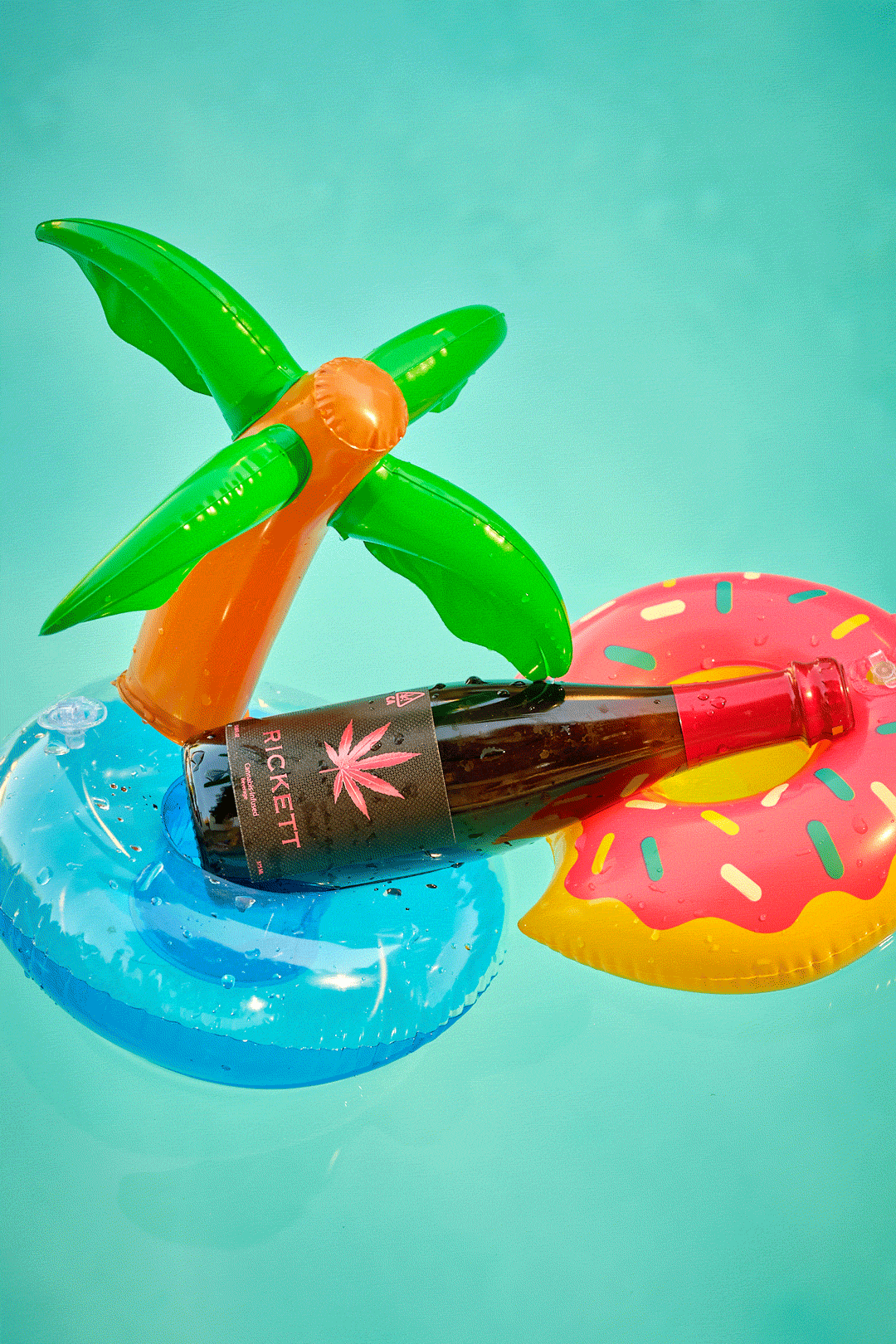A bottled cannabis beverage lounging on two pool floaties.