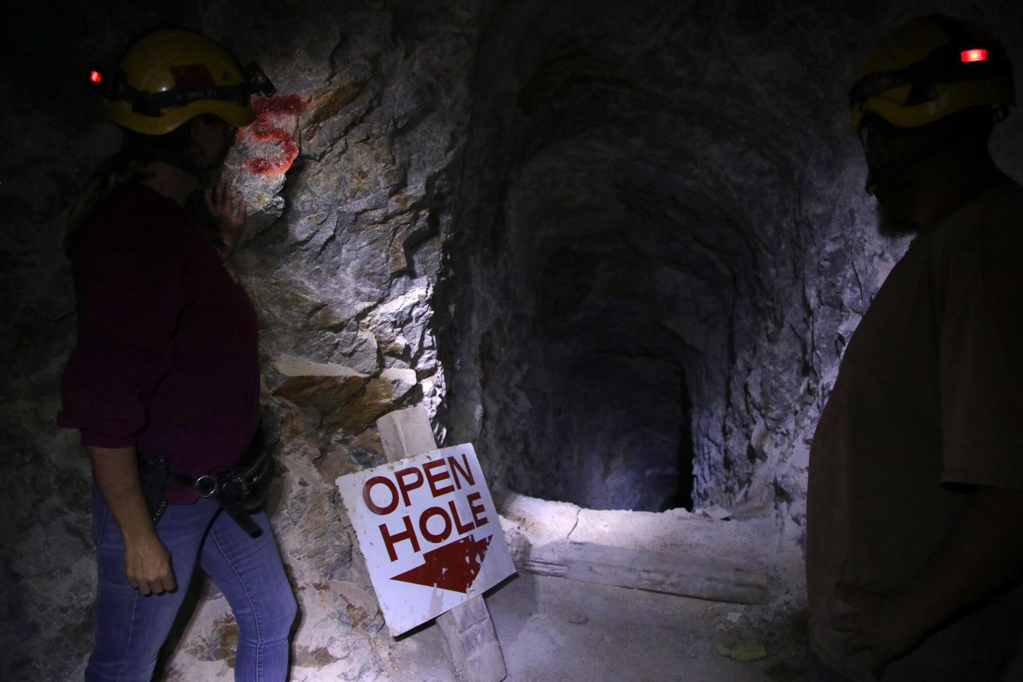 A chasm inside a cave, with a sign reading "OPEN HOLE" and an arrow pointing down.
