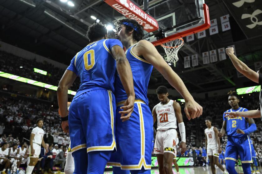 UCLA guard Jaylen Clark (0) is greeted by UCLA guard Jaime Jaquez Jr. after being fouled by Maryland guard Jahmir Young during the first half of an NCAA college basketball game, Wednesday, Dec. 14, 2022, in College Park, Md. (AP Photo/Terrance Williams)