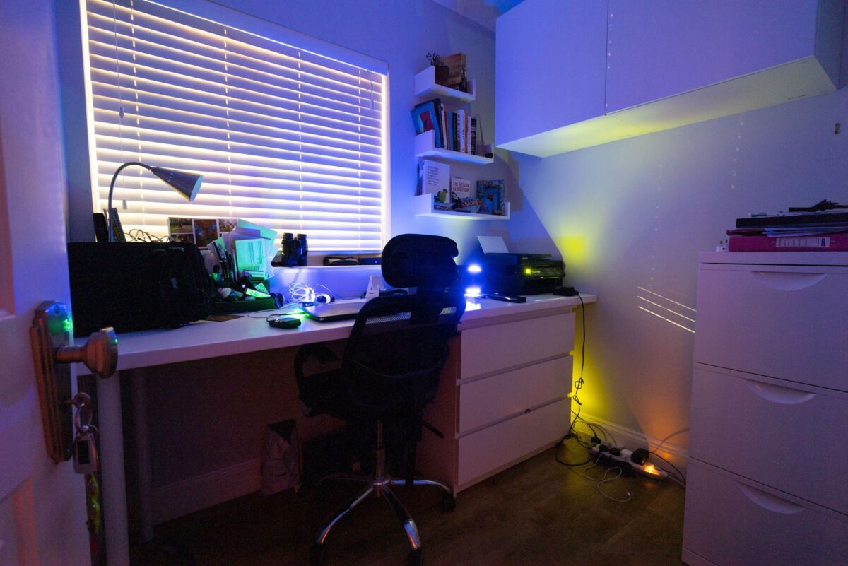 A home study illuminated by electrical devices on standby.