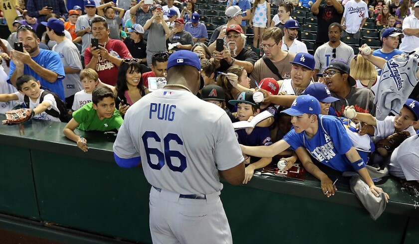 Dodgers outfielder Yasiel Puig signs autographs for fans before a game against the Diamondbacks in Arizona. For fans who don't have Time Warner Cable, leaving L.A. is one way to see their favorite club play.
