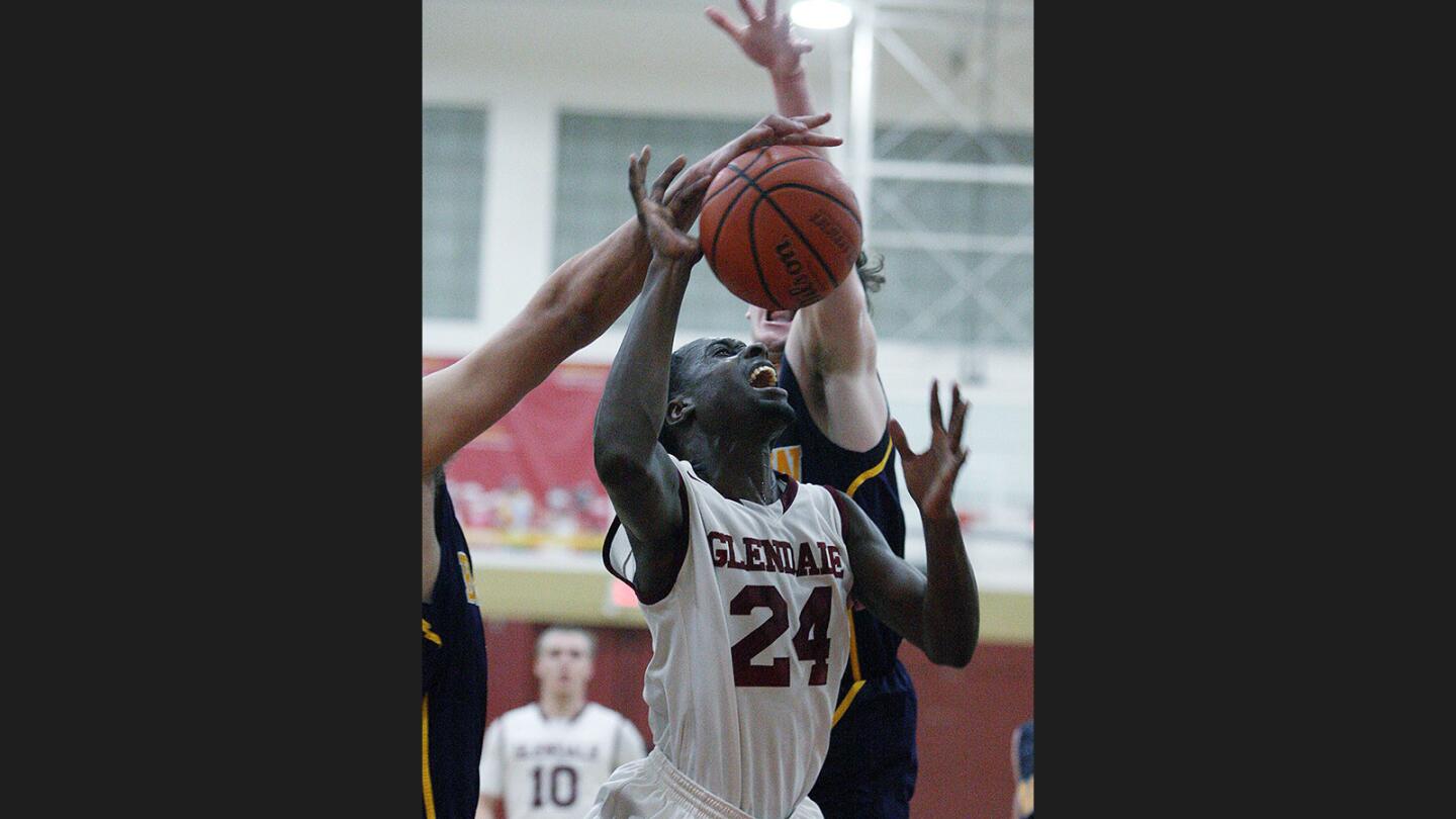 Glendale College's Serigne Athj drives to the basket to shoot, but is fouled on the way by Barstow in a men's basketball game at Glendale College on Wednesday, January 18, 2017.