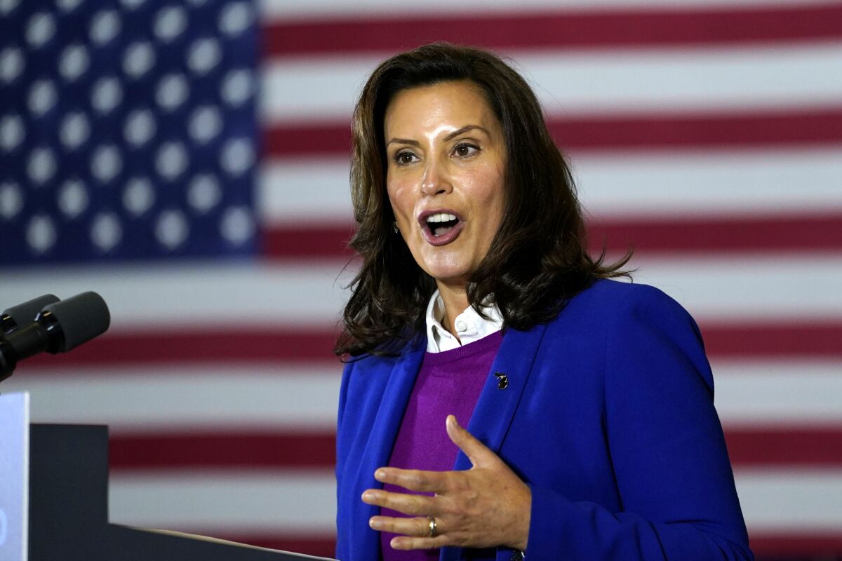 Gretchen Whitmer speaks at a podium with the U.S. flag in the background.