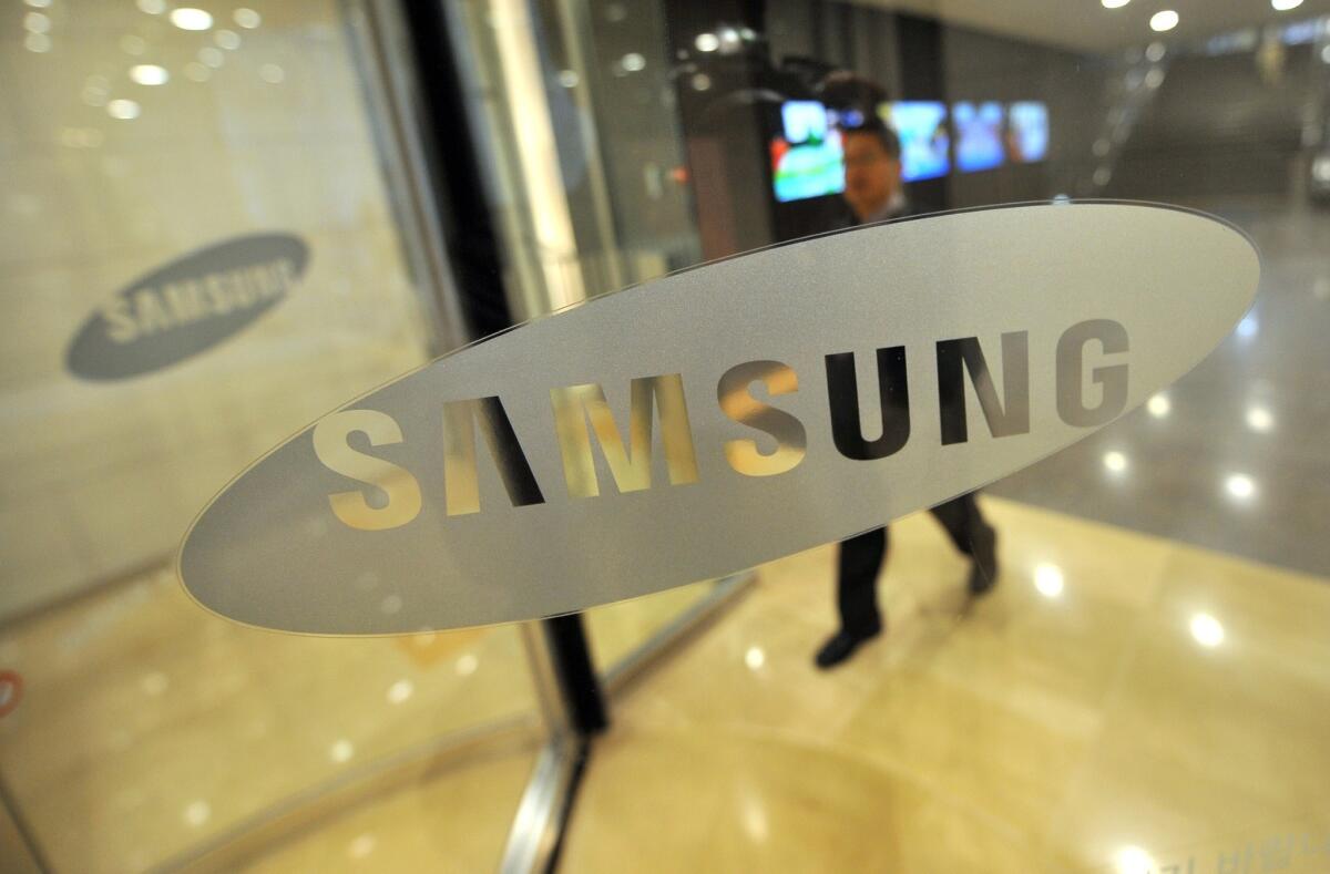 The Samsung logo is displayed on a glass door at its headquarters in Seoul.