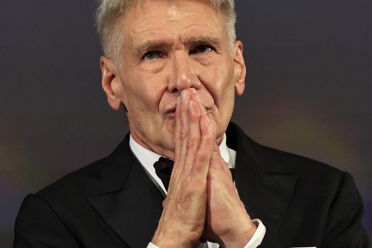 Harrison Ford reacts to his honorary Palme d'or prior to the screening of the film "Indiana Jones and the Dial of Destiny." 