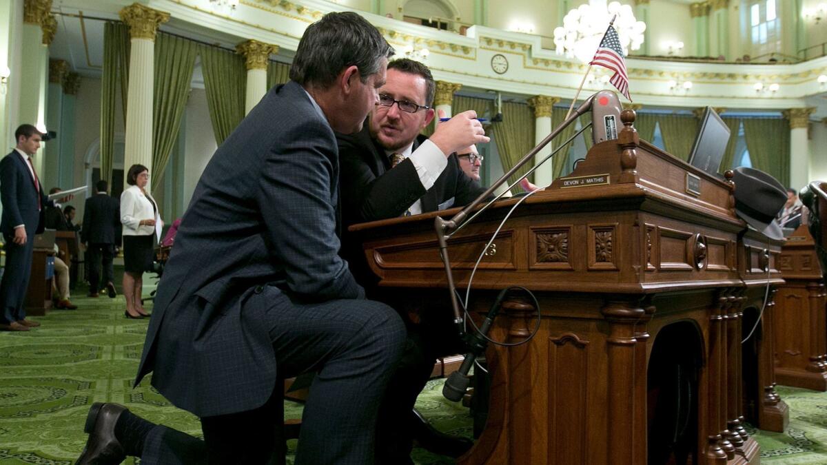 Assemblyman Jim Wood (D-Healdsburg) talks to Assemblyman Devon Mathis (R-Visalia) during Monday's Assembly floor session in Sacramento. For the first time, the end of a legislative session is subject to a new rule that bills must be in print for 72 hours.