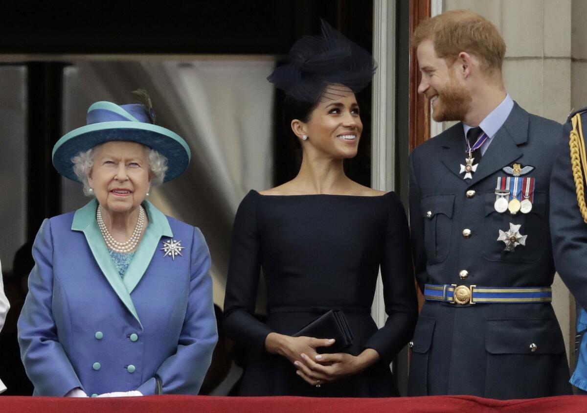 Queen Elizabeth in a purple coat with Duchess Meghan and Prince Harry  