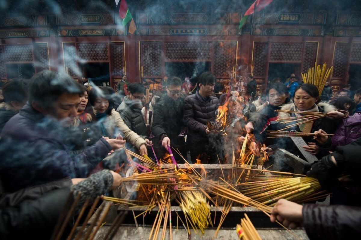 Worshipers burn incense as part of lunar new year festivities at the Yonghegong lama temple in Beijing.