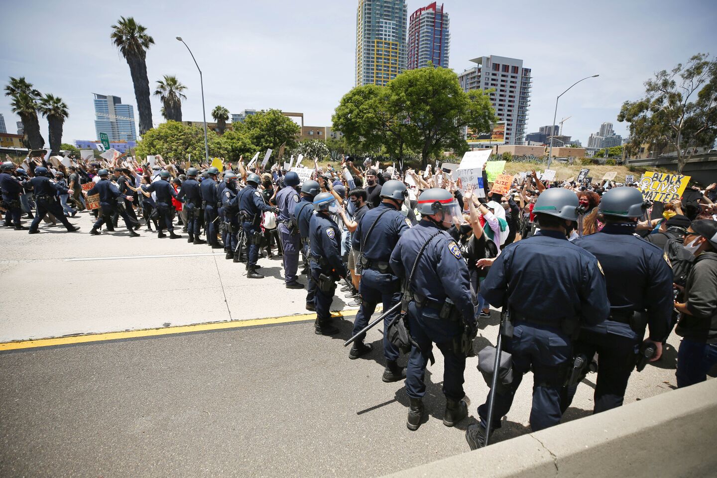 CHP officers try to hold back protesters as they march down I-5 in downtown San Diego on May 31, 2020.