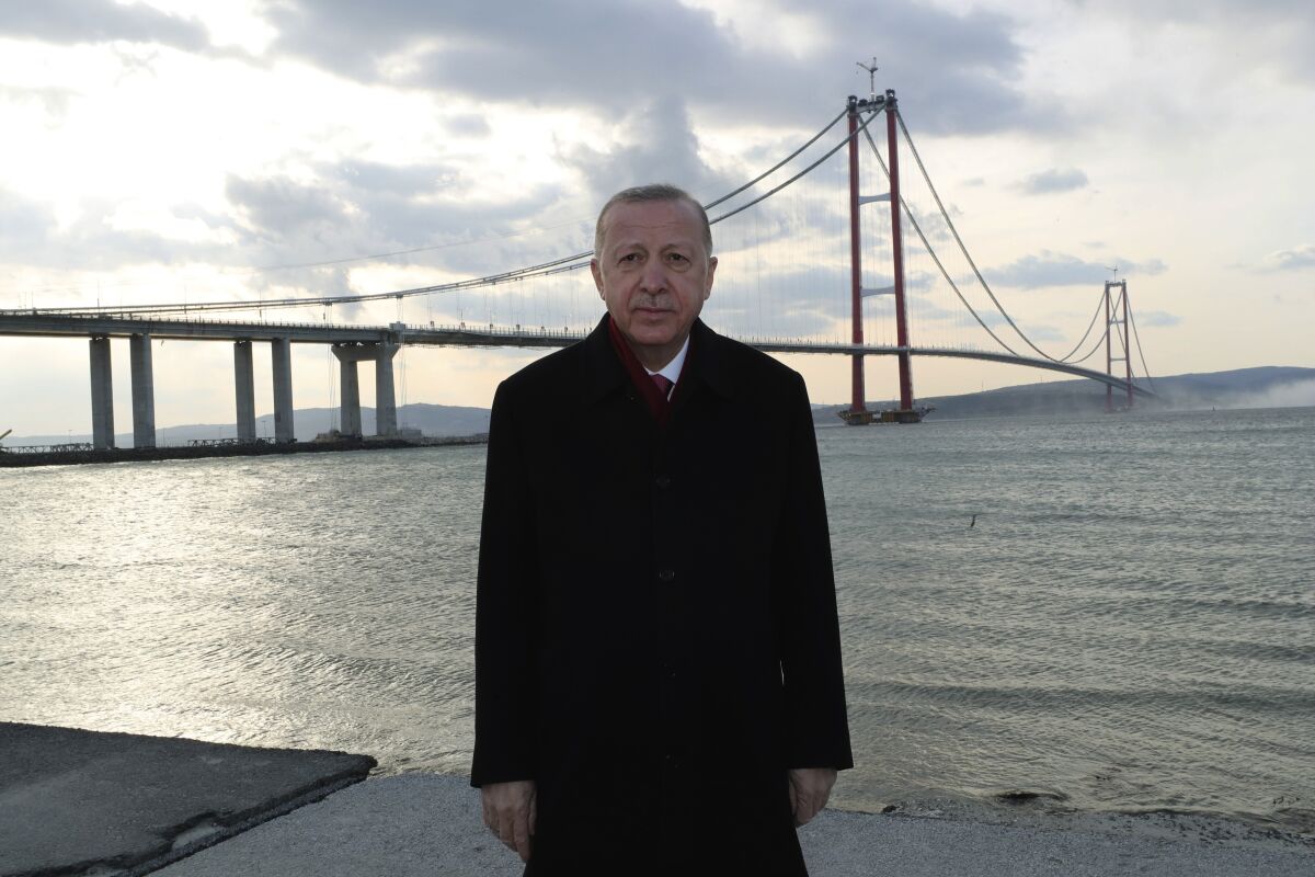 Turkey's President Recep Tayyip Erdogan poses for photos in front of the 1915 Canakkale Bridge, in Çanakkale, western Turkey, Friday, March 18, 2022. The bridge links the Asian side of Turkey with European side over Dardanelles Strait. South Korean Prime Minister Kim Boo-kyum also attended the opening ceremony. (Turkish Presidency via AP)