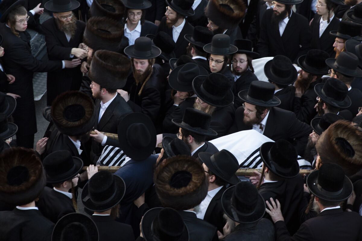 Ultra-Orthodox men carry the bodies of Moshe Englard, 14, and his brother, Joshua, 12, who died during Lag BaOmer celebrations at Mt. Meron in northern Israel, in Jerusalem on Friday, April 30, 2021. A stampede at the religious festival attended by tens of thousands of ultra-Orthodox Jews in northern Israel killed dozens of people and injured about 150 early Friday, medical officials said. It was one of the country's deadliest civilian disasters. (AP Photo/Ariel Schalit)