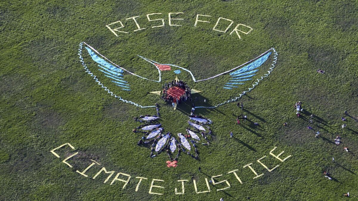 More than 20 indigenous leaders and supporters gather to create a "Solar Hummingbird" human installation Sunday near San Francisco's Golden Gate Bridge to produce a visual message calling for climate justice and indigenous rights.