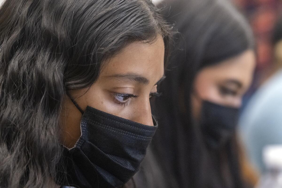 Denyse Molina, 16, takes notes during a history class