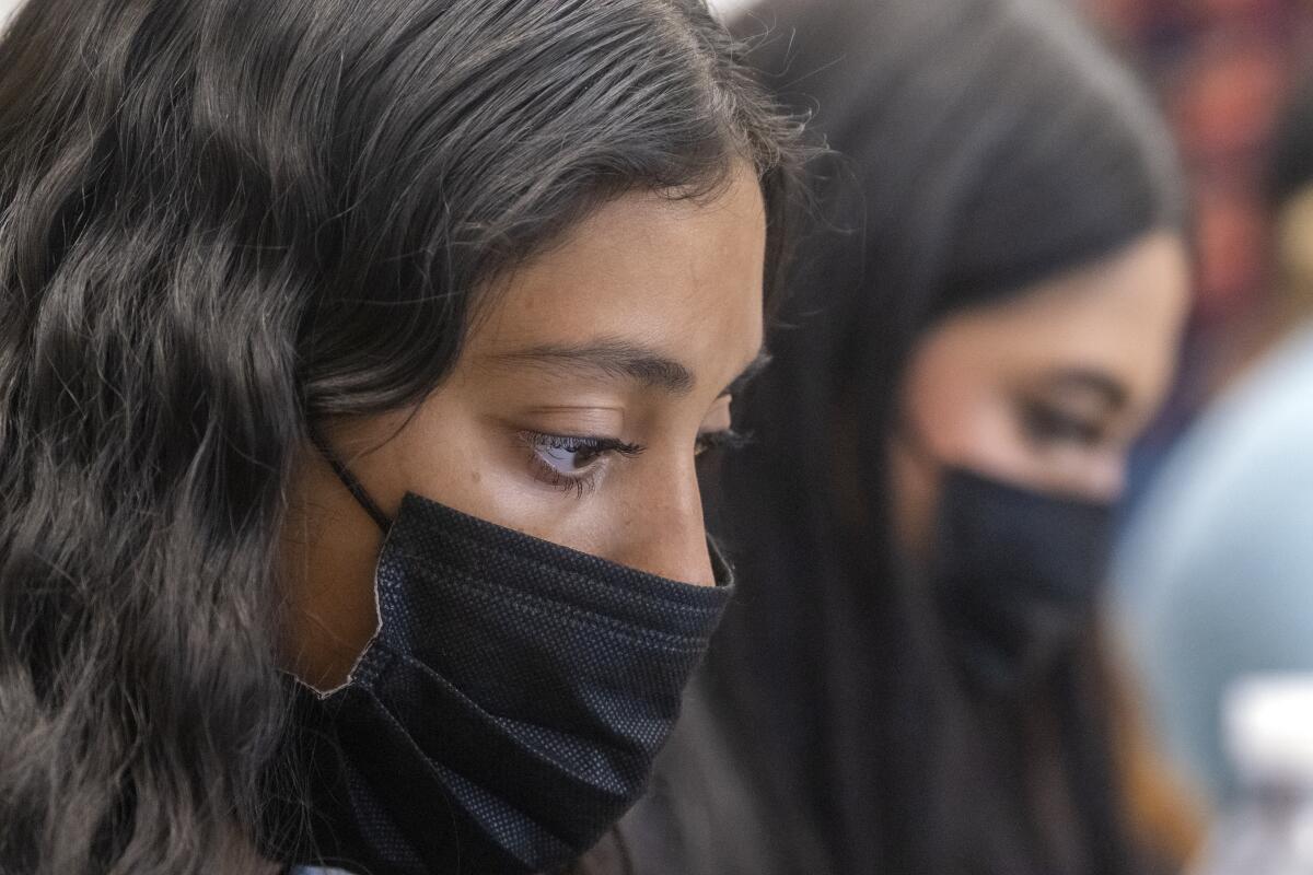 Denyse Molina, 16, takes notes during a history class 