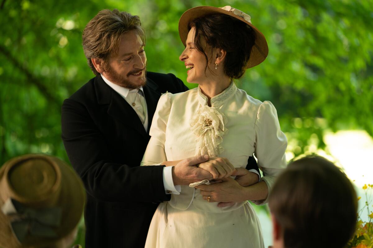 A man and a woman smile during their outdoor wedding.