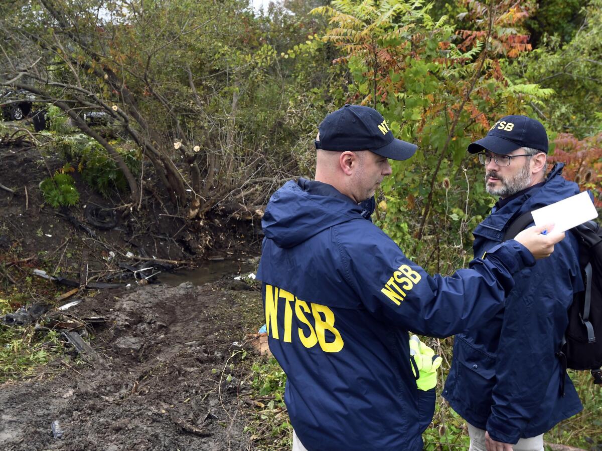 Members of the National Transportation Safety Board view the scene of Saturday's fatal crash in Schoharie, N.Y.